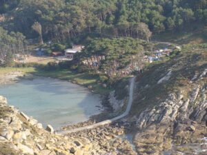 berg met in de verte een bosrand met daarvoor een camping