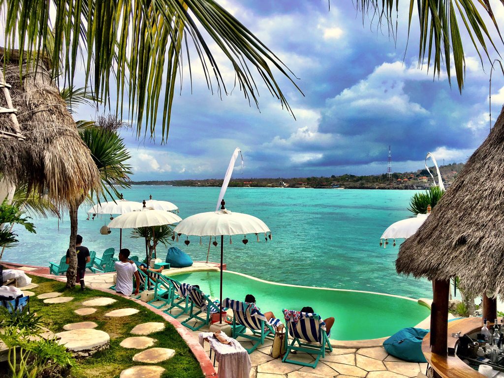 zwembad met terras er omheen met uitzicht op zee