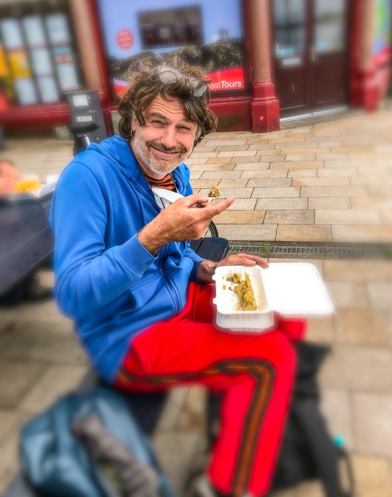 zittende man eet een typisch schots gerecht uit een bakje . Haggis