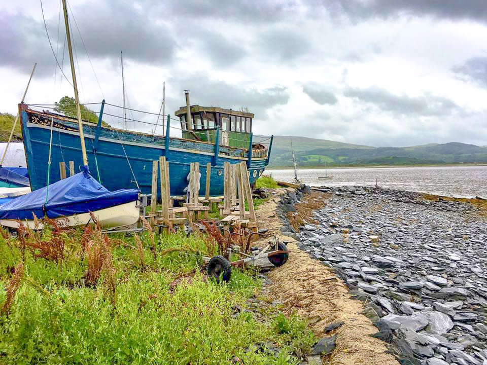 Blauwe houten boot op de wal