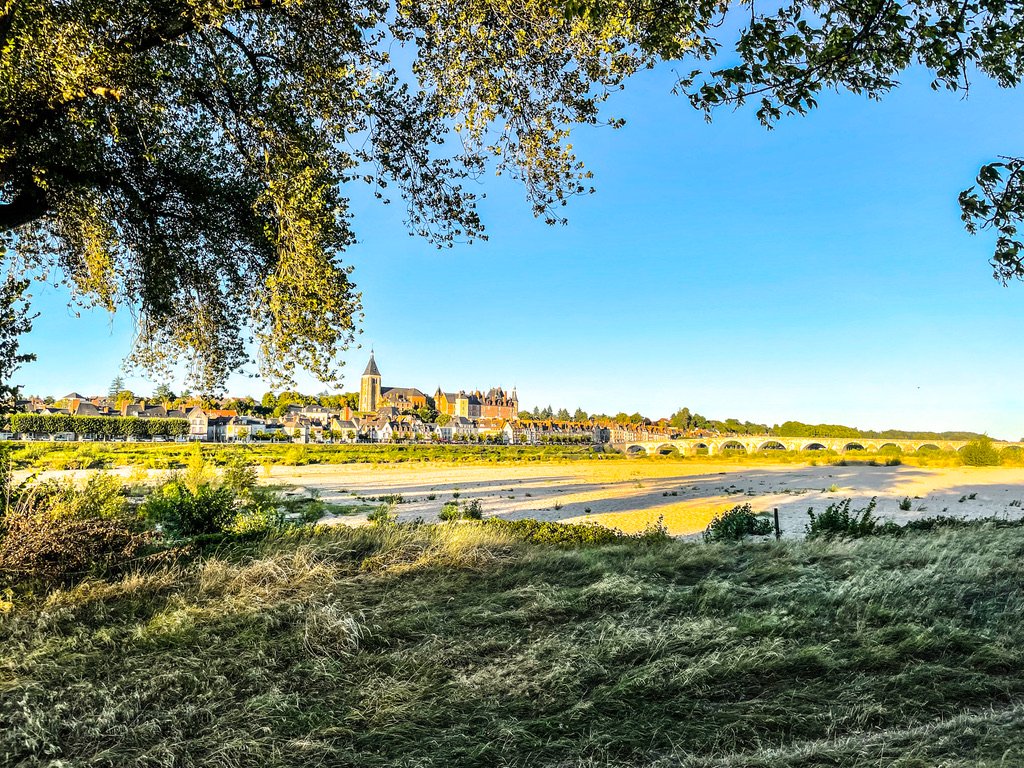 links een boom in de verte een Frans stadje aan een rivier