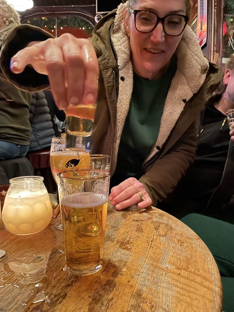 Vrouw in cafe met een glas bier op de voorgrond