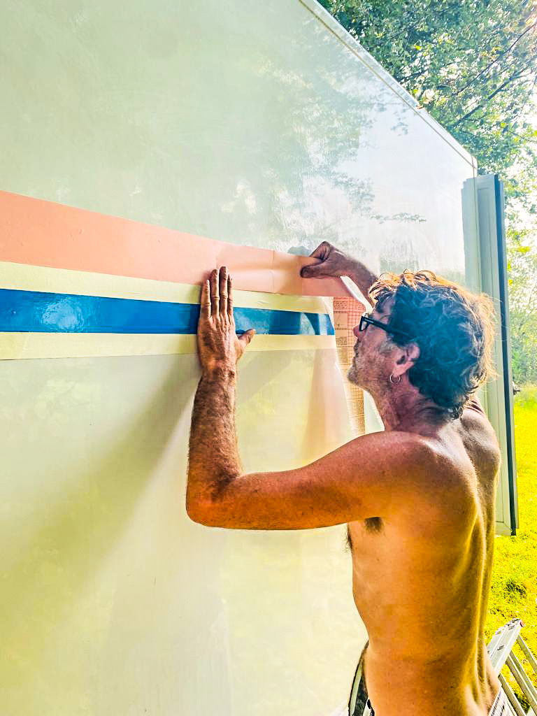 man plakt letters op een witte bus