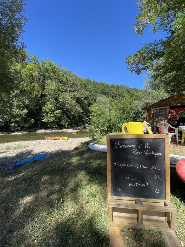 Schoolbord op een grasdijk met links een rivier