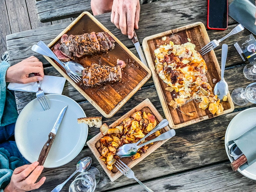 houten tafel met borden erop en handen