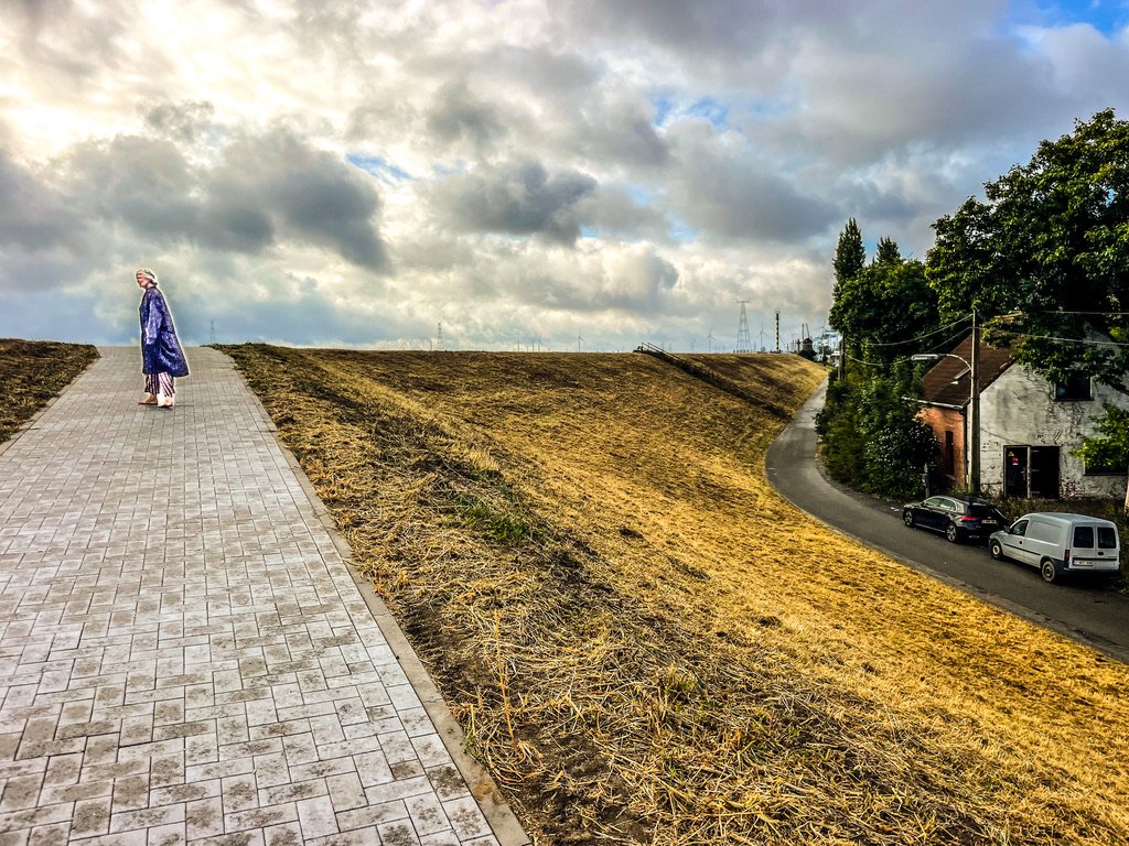 vrouw op de dijk met rechts een huisje